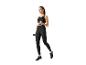Femme en leggings et top noirs faisant des exercices avec des haltères.