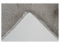 Un tapis en fourrure gris avec un dessous antidérapant blanc.