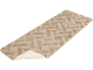 Tapis de couloir beige à motif géométrique, partiellement enroulé pour montrer l'envers.