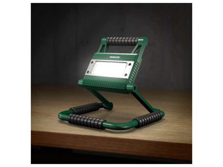 Une lampe de travail Parkside verte avec un pied réglable.