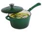 Casserole en fonte émaillée verte avec couvercle, remplie de soupe verte