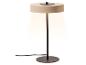 Lampe de table moderne beige et noire avec lumière chaude, isolée sur blanc.