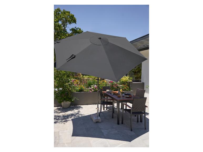Ensemble de mobilier de jardin avec parasol, table et chaises sur une terrasse.