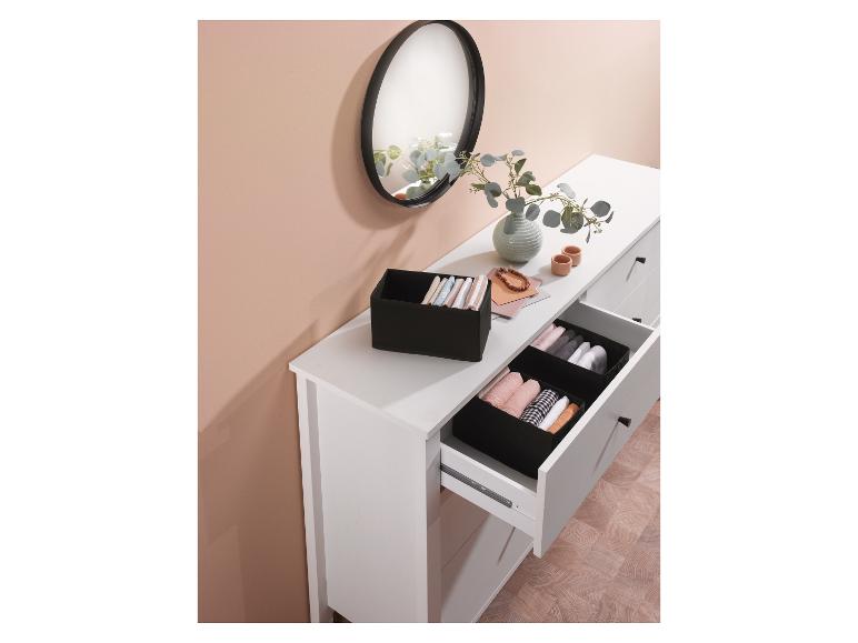 Tiroirs de commode ouverts avec organisateurs en tissu noir remplis de vêtements pliés