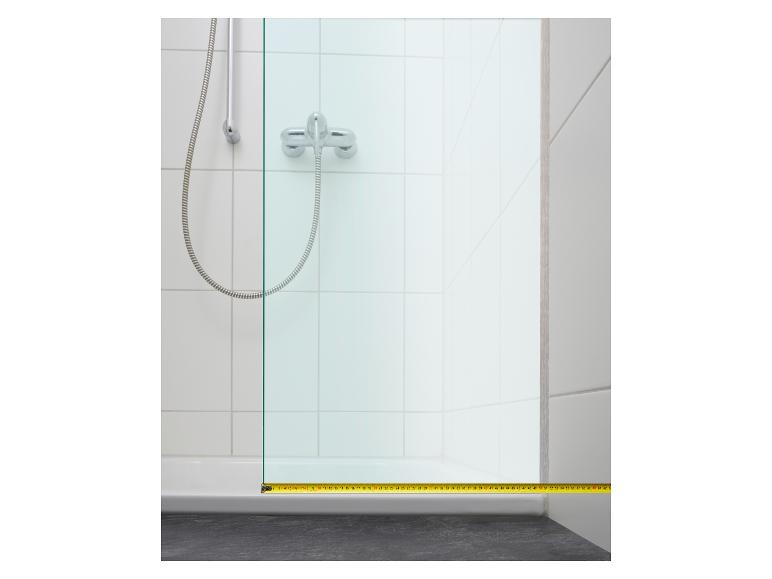 Mesure d'une cabine de douche avec un ruban à mesurer.