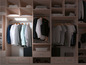 Une armoire avec différents vêtements, y compris des chemises et une veste.