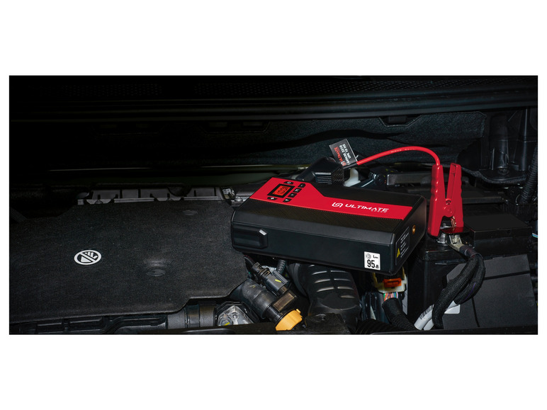 Un Ultimate Jumpstarter avec des pinces rouges connecté à une batterie de voiture.