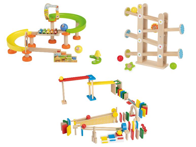 Trois ensembles de jouets en bois : un circuit de billes, un circuit de billes avec un xylophone et un circuit de dominos.