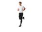 Homme en t-shirt blanc et legging noir en train de courir.