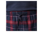 Un gros plan de pantalon de pyjama à carreaux rouges et bleus