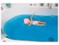 Poupée en maillot de bain rose et bonnet de bain, flottant dans une baignoire d'eau bleue.