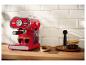 Machine à expresso rouge rétro préparant du café sur un comptoir en bois.