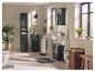 Salle de bain avec meubles noirs, lavabo, toilettes, plantes et textiles.