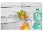 Un réfrigérateur avec des fruits, des kiwis et des raisins dans un récipient transparent, une bouteille d'eau et des oranges