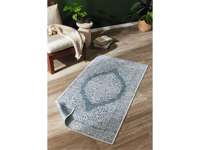 Un tapis bleu avec un motif blanc détaillé.