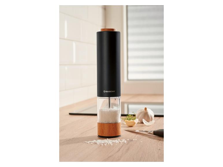 Moulin à sel noir avec éléments en bois sur un comptoir de cuisine.