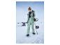 Une femme en pantalon et veste de ski verts avec un snowboard dans la neige.