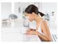 Une femme utilise un vaporisateur facial.