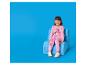 Petite fille en pyjama rose à motif de princesse assise sur une chaise bleue.