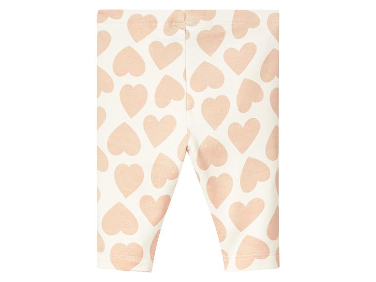 Leggings blanches à motif de cœurs roses.