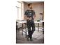 Un homme porte des vêtements de travail, y compris un t-shirt à imprimé camouflage et des chaussures de travail noires.