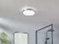Un luminaire de plafond rond dans une salle de bain avec une cabine de douche.