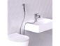 Des toilettes avec une douchette pour bidet et un lavabo avec un robinet.