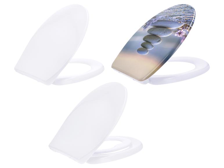 Trois abattants de toilettes, dont un avec un imprimé zen de pierres et de fleurs.