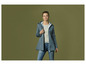 Une femme en veste softshell bleue et en jean.