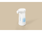 Distributeur de savon automatique blanc avec une touche de bleu, sur fond beige.