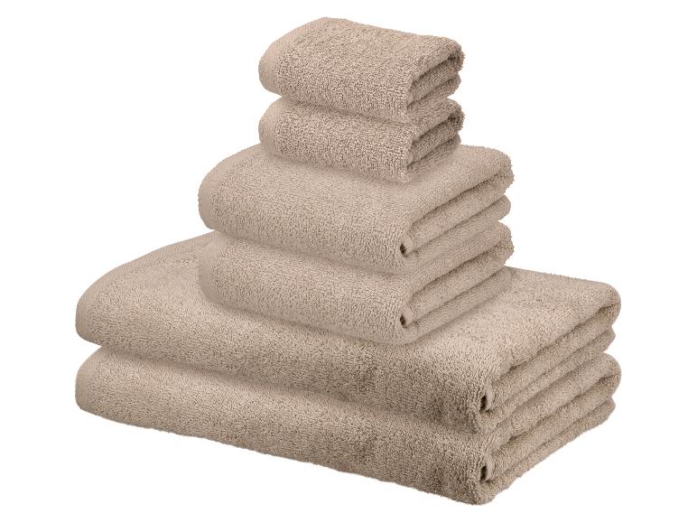 Pile de serviettes beiges de différentes tailles.