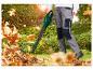 Homme avec un souffleur de feuilles électrique nettoyant les feuilles mortes dans le jardin.