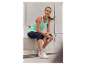Femme en vêtements de sport Crivit se reposant sur des marches avec une bouteille d'eau.