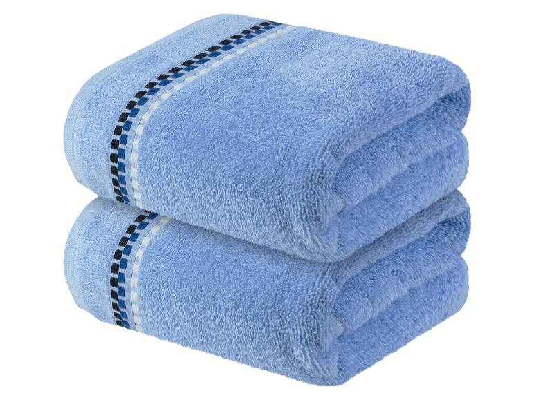 Deux serviettes de bain bleues avec un motif géométrique.