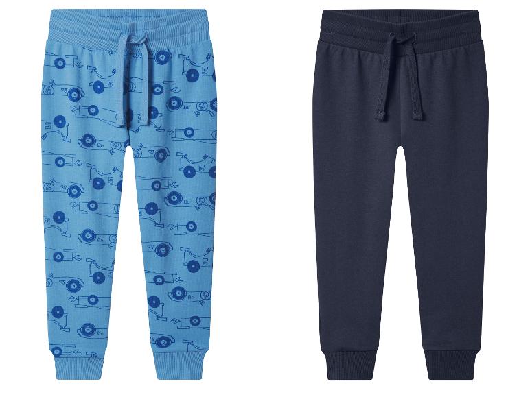 Deux pantalons de survêtement pour enfants : un bleu avec imprimé voiture et un bleu foncé.