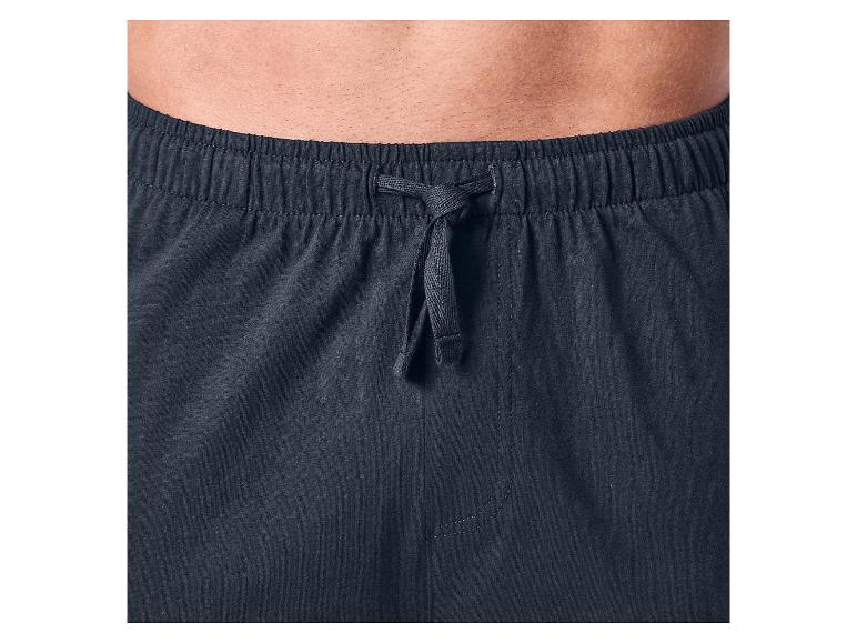 Gros plan du torse d'un homme portant un pantalon de détente bleu foncé avec cordon de serrage.