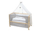 Un lit bébé en bois avec un ciel de lit et un rembourrage gris.