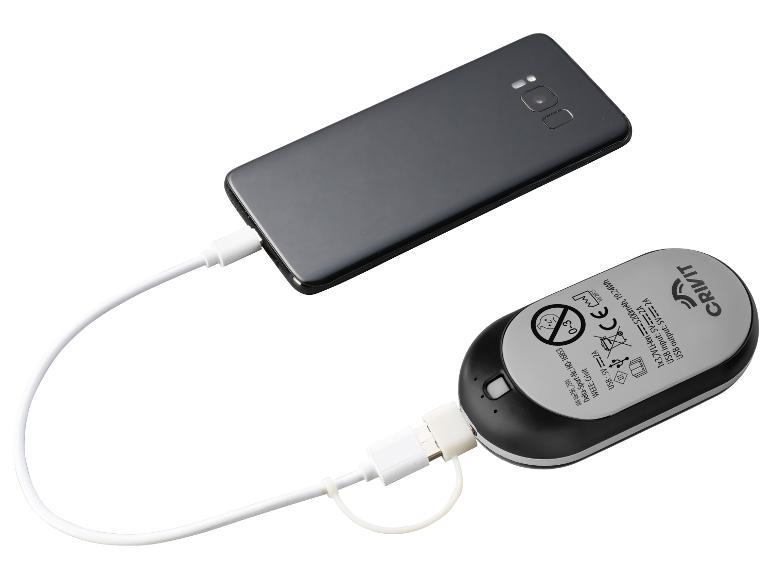 Smartphone en charge depuis un chargeur portable, affichant les spécifications du chargeur.