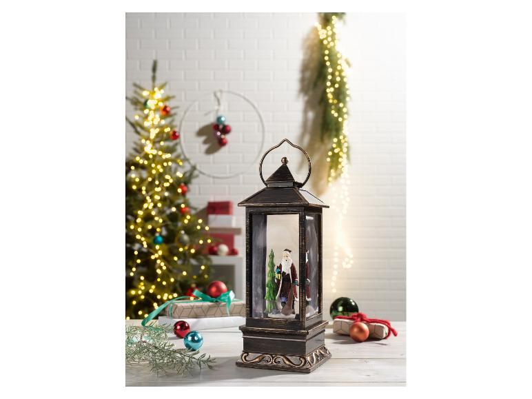 Lanterne de Noël avec figurine du Père Noël et sapin de Noël en arrière-plan