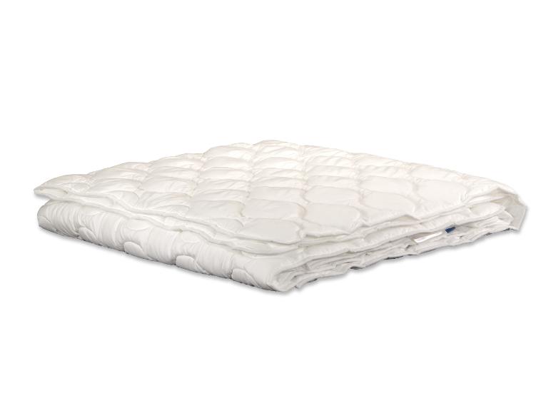 Couette blanche matelassée, pliée, avec un motif de losanges