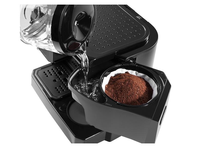 Verser de l'eau dans une cafetière avec du café moulu dans le filtre.