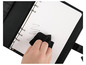 Une main essuie un agenda à anneaux ouvert avec un chiffon noir