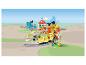 Un ensemble de train LEGO Duplo avec une locomotive jaune, des rails, une gare et des figurines.