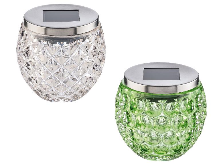 Deux lampes solaires en verre, une transparente à motif losanges, une verte à motif bulles.