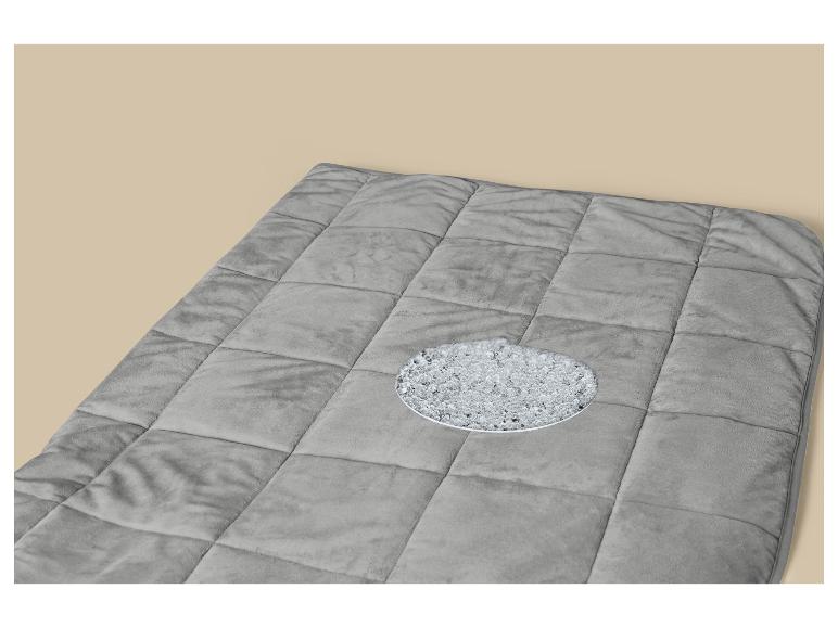 Couverture lestée grise avec une découpe montrant le remplissage de billes de verre.