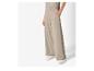 Pantalon large beige avec des baskets blanches.