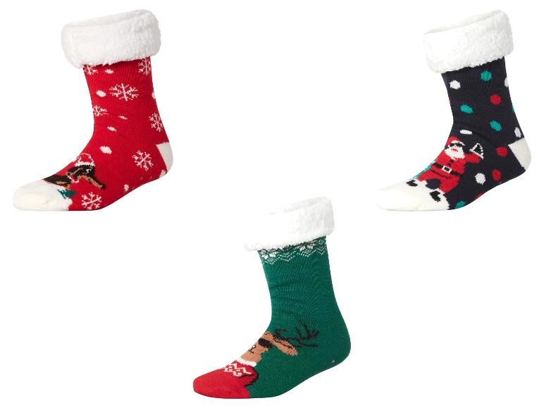 Trois paires de chaussettes de Noël festives avec des revers blancs moelleux, représentant le Père Noël, des rennes et des flocons de neige.