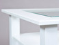 Table basse blanche avec plateau en verre.
