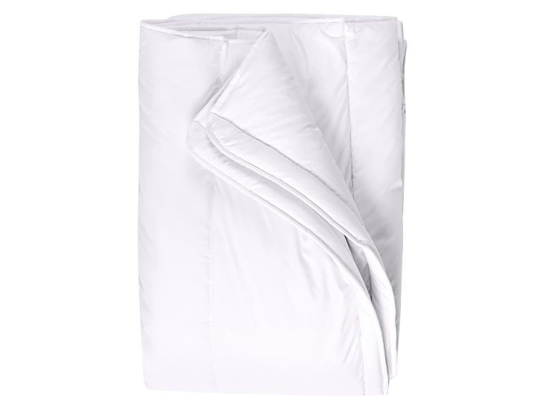 Couette blanche pliée sur fond blanc.