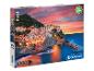 Boîte de puzzle Clementoni de 1000 pièces avec une image d'un village italien sur la côte au coucher du soleil.